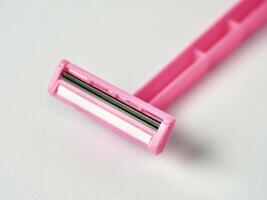 Close up one pink colored razor tool object isolated on horizontal ratio white background. photo
