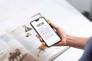 Smartphone with OCR app instantly scanning and digitizing book text, symbolizing modern technology's ability to bring printed words to life through real-time text recognition photo