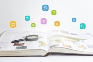 Open book and magnifying glass with floating icons, learning, search, atoms, brain, knowledge, dialogue, question mark. Ideal for education, curiosity, research, knowledge-sharing photo