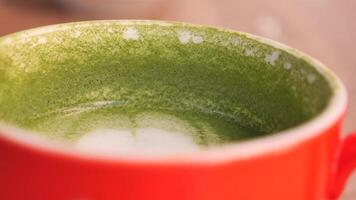 matcha latte in a red color cup on table video