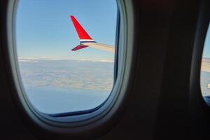 View of airplane wing from an airplane window. Air travel and flight concept photo