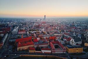 Aerial view of Wroclaw old town with red roofs, churches and the Sky Tower building in background at sunset. Panorama of Wroclaw, Poland photo