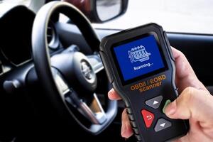 OBDII Scanner in use by auto mechanic for reading fault code of the car engine system , Car repair concept photo