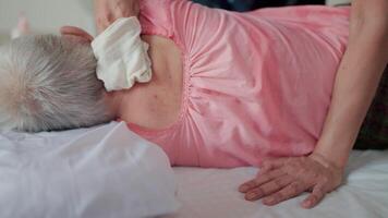 Close-up With a soft cloth and gentle touch, a loving child massages the neck of their elderly parent, providing comfort and relaxation in a tender moment of care. video