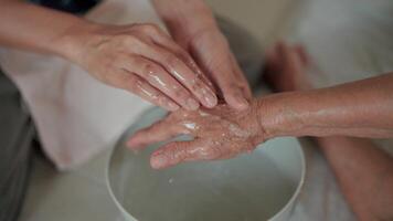 Close-Up of Hands Washing and Gently Touching Elderly Parent, Showing Love and Hygiene in a Home Care Setting. video