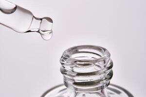 Close-up of a cosmetic bottle with a pipette showing the texture of the serum. photo