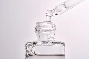 Close-up of a cosmetic bottle with a pipette showing the texture of the serum. photo