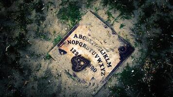 Witchcraft Spiritual Halloween Game Ouija Board on Soil and Grass Ground photo