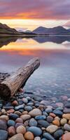 Serene sunset over tranquil lake with colorful pebbles by shore photo