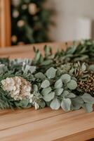 Various greenery and floral elements arranged on a wooden table photo