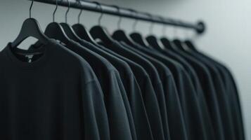 Black sweatshirts neatly arranged on a rack in a modern retail setting photo