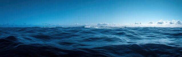 Ocean waves under a clear sky during midday in a serene location photo