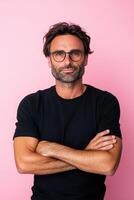 A sad man with glasses crossing arms against a pastel pink backdrop photo