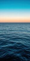 Calm ocean waves reflecting colorful sky at sunset over the horizon photo