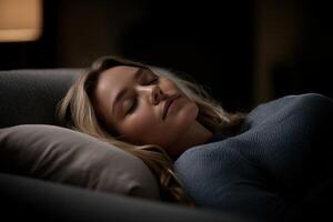 Woman resting peacefully on a sofa in dimly lit room photo