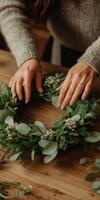 Creating a beautiful green wreath with natural elements and hands photo