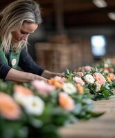 Florist arranging fresh flowers in a workshop during daylight hours photo