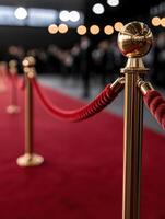 Red carpet event with golden stanchions and bright bokeh lights photo