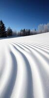 Snowy landscape with wave-like patterns under a clear blue sky photo
