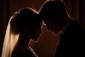 Couple embraces in silhouette during wedding ceremony at dusk photo