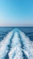 Calm blue ocean with boat wake under clear sky during daytime photo