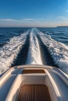 Boat departing from shore leaving a strong wake on the water photo