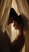 Newlyweds share a romantic moment behind soft fabric at sunset photo