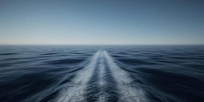Tranquil ocean view with boat wake under clear blue sky photo