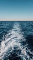 Waves gently ripple across the calm ocean during sunset photo