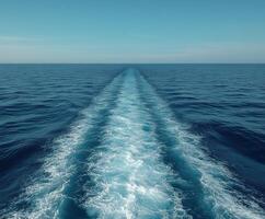 Waves created by a boat moving through a calm ocean on a sunny day photo