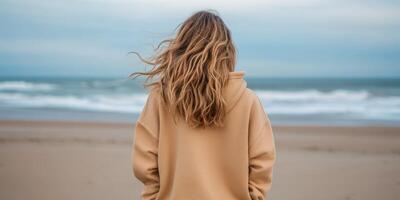 Woman enjoying the ocean breeze on a quiet beach day photo