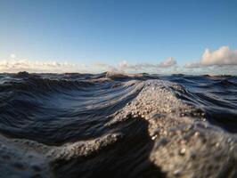Waves gently rolling in under a clear blue sky at dusk photo