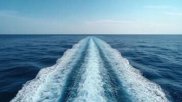 Cruise ship leaves a wake in the calm blue ocean under sunny skies photo