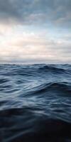 Calm ocean waves under a cloudy sky during sunrise photo