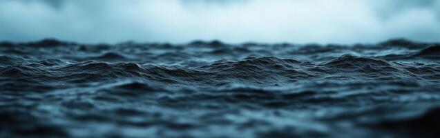 Dark rolling waves under cloudy sky create a serene atmosphere photo
