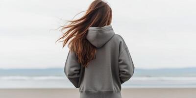 Young woman enjoys a quiet moment by the beach on a cloudy day photo