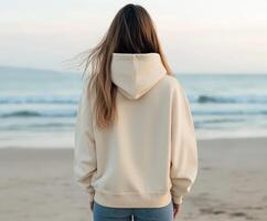 Woman standing on beach facing the ocean at sunset photo