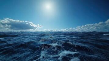 Waves under a bright sun with scattered clouds in the sky photo