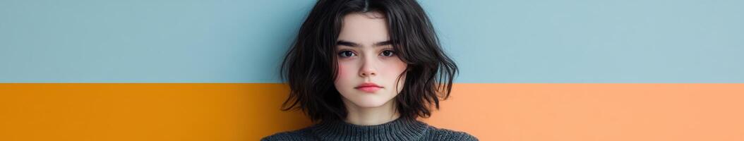 Portrait of a young woman with dark hair against colorful backdrop photo