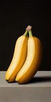 Two ripe bananas resting on a gray surface with a dark background photo