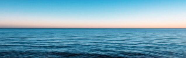 Calm ocean view at sunset with gentle waves and colorful sky photo