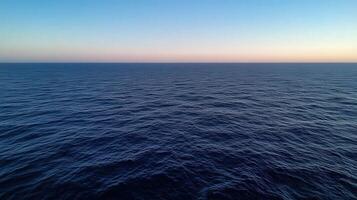 Calm blue ocean waves stretching to the horizon at sunset photo