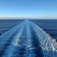 A clear ocean view with wave patterns from a moving boat at sunset photo