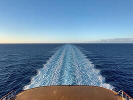 Cruise ship sailing on a clear day with ocean waves in the background photo