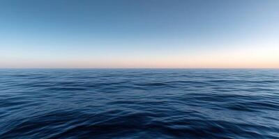 Calm ocean waters at sunset with a clear sky and gentle waves photo