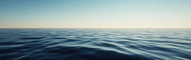 Calm ocean waves under clear blue sky at dawn with horizon view photo