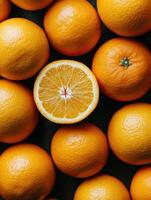 Fresh oranges arranged with one cut open on a dark surface photo