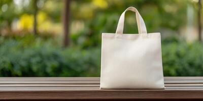 Simple white tote bag resting on a wooden table in a park photo