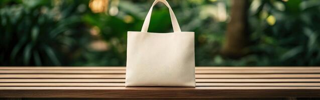 A simple fabric tote bag on a wooden table in a lush outdoor setting photo