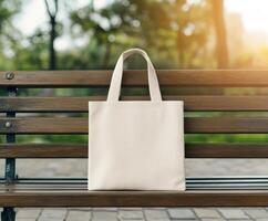 A blank canvas tote bag resting on a park bench at sunset photo
